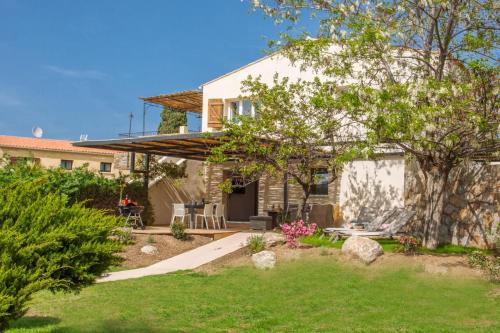 una casa con un jardín delante de ella en Villa Albizzia with terrace and garden 6 8 people en Calvi