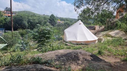 biały namiot siedzący na szczycie wzgórza w obiekcie ESPACIO AMAITÀ w mieście Villa Carlos Paz