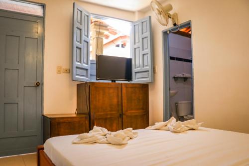 a bedroom with a bed with a mirror and a tv at Aura Hotel Parque Barichara By Infinity in Barichara
