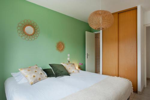 um quarto com uma grande cama branca com almofadas em Apartment "Jasmin" 3 bedrooms with large terrace 68 people em Calvi