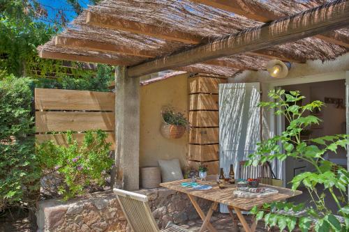 a patio with a table and chairs in a yard at Small quiet house Dracena with its pretty garden - 2 people in Calvi