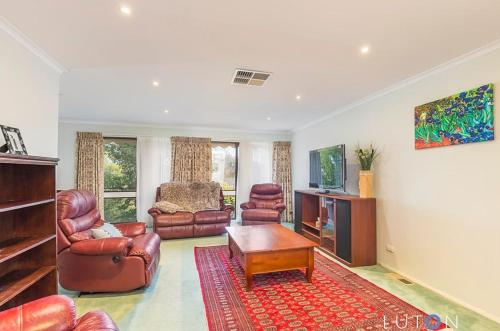 a living room with leather furniture and a tv at Convenience location with large living areas in Kambah