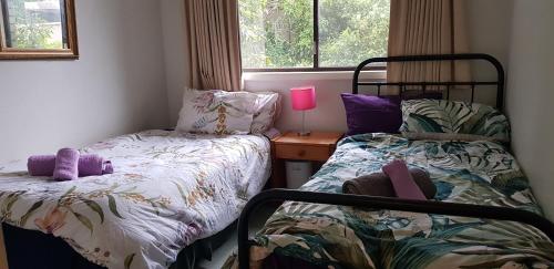 a small bedroom with two beds and a window at Convenience location with large living areas in Kambah