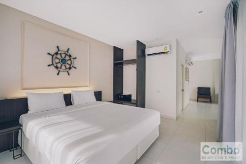 a bedroom with a large white bed with a ship on the wall at Combo Beach Hotel Samui in Chaweng