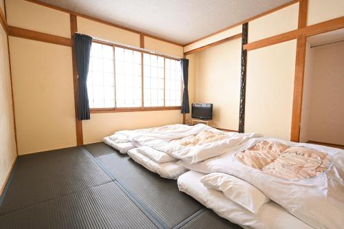 een groot bed in een kamer met een raam bij Hütte Jil Shirakabako in Chino