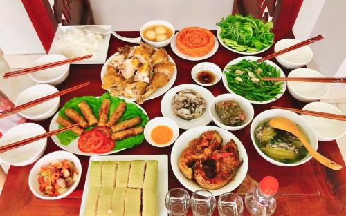 a table with many different dishes of food on it at Thành Nghiêm Hotel Ninh Hòa in Ninh Hòa