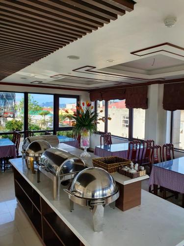 a restaurant with several silver domes on a table at Thành Nghiêm Hotel Ninh Hòa in Ninh Hòa