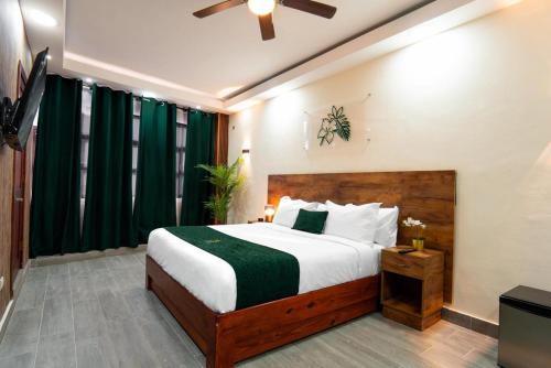 um quarto com uma cama grande e uma televisão em Jardin Colonial Boutique Hotel em Santo Domingo