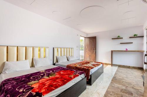 a bedroom with two beds and a tv at Aravali hills resort in Gurgaon