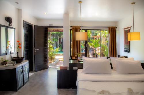 a bedroom with two beds and a living room at Bunwin Siem Reap in Siem Reap