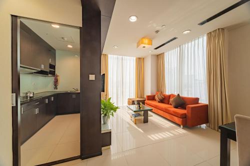 sala de estar con sofá naranja y mesa en Mayfair Suites, en Ho Chi Minh