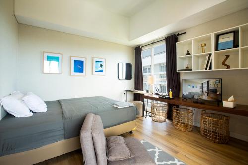 a bedroom with a bed and a desk and a window at Montero- Casa De Parco Panoramic View Apartment in Tangerang