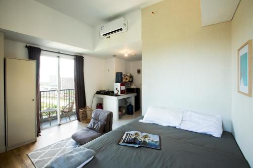 ein Schlafzimmer mit einem Bett und einem Stuhl sowie einem Balkon in der Unterkunft Montero- Casa De Parco Panoramic View Apartment in Tangerang