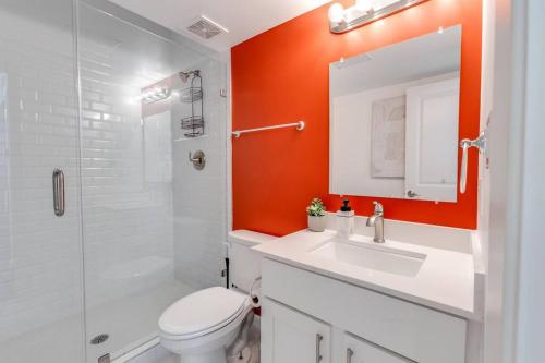 an orange bathroom with a toilet and a sink at 1 BD Lux Retreat (Museum District/ Medical Center) in Houston