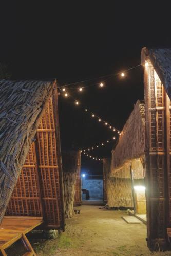 un grupo de cabañas con luces por encima de ellas por la noche en Balay Inton near Masasa Beach Tingloy en Tingloy