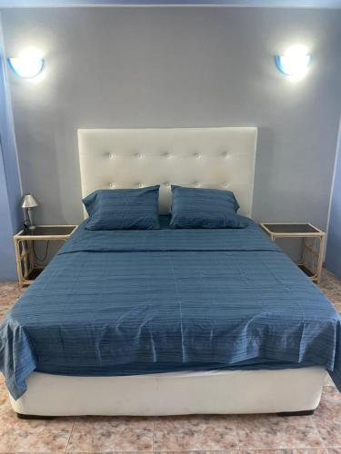 a bedroom with a large bed with a blue comforter at Contry Mar Caraballeda in Caraballeda