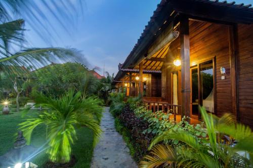 a house with a pathway next to a building at D'Muncuk Huts Lembongan in Nusa Lembongan