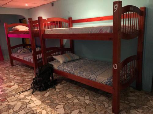 2 stapelbedden in een kamer met een bed en een kussen bij Hostal Portobelo in Portobelo