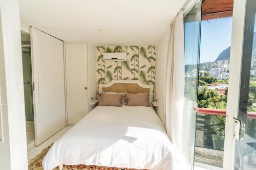 um quarto com uma cama e uma grande janela em Unbelievable PH, Leblon! Amazing view and privacy! no Rio de Janeiro