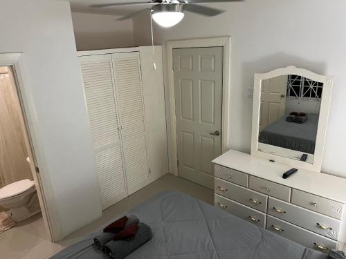 een slaapkamer met een bed, een spiegel en een dressoir bij Mandeville luxury in Mandeville