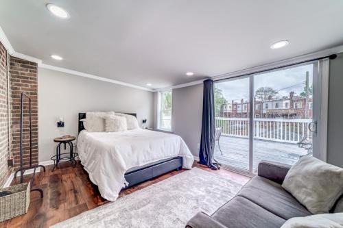 a bedroom with a bed and a couch and a large window at TheWrightStays Art Haven at Fairlawn Gardens in Washington, D.C.