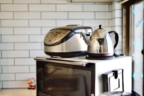 a tea kettle is sitting on top of a microwave at 広い庭付きBBQ可,残波ビーチまで車で5分,最大人数11名 Ns garden in Jima
