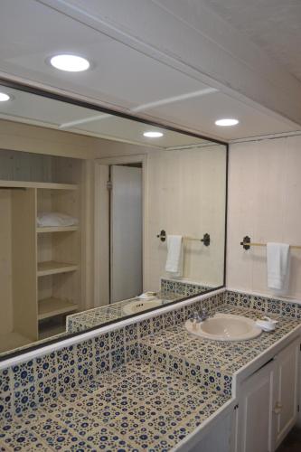 a bathroom with a sink and a large mirror at Hotel Quintas Papagayo in Ensenada