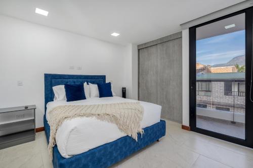 a bedroom with a large bed and a large window at MEDELLIN- Cerca al Poblado - 301 in Medellín
