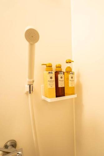 a shelf with four bottles of honey on a wall at 錦・【金瑞軒】名古屋駅徒歩8分まるまる貸切 in Nagoya