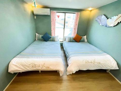 - 2 lits jumeaux dans une chambre avec fenêtre dans l'établissement 錦・【金瑞軒】名古屋駅徒歩8分まるまる貸切, à Nagoya