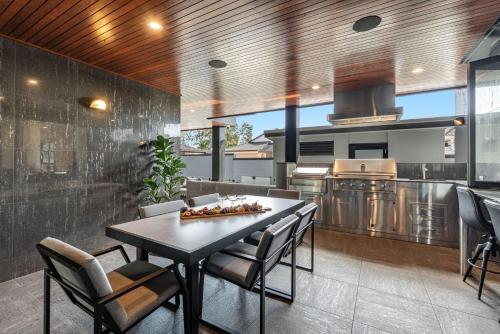 a kitchen with a table and chairs in a room at Jasmine cove - Exclusive Waterfront Estate in Yamba