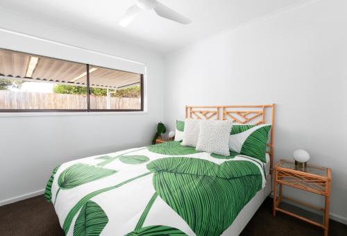 a bedroom with a bed with green leaves at "Julies"-Big fenced yard, nearby beach, Pet friendly in Ocean Grove