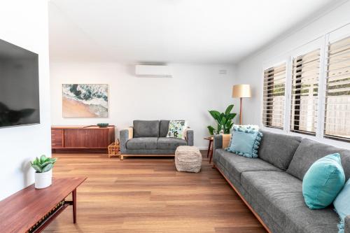 a living room with a couch and a table at "Julies"-Big fenced yard, nearby beach, Pet friendly in Ocean Grove