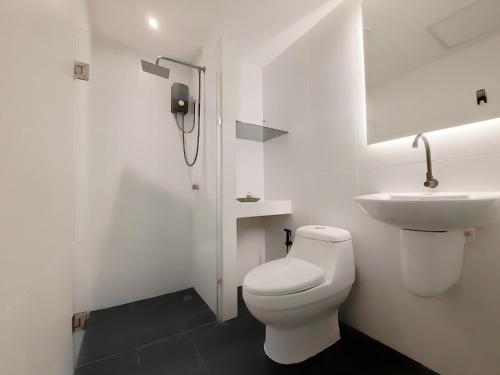Un baño blanco con inodoro y lavabo. en Watket Hotel โรงแรมวัดเกต, en Chiang Mai