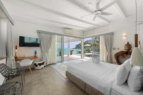 a bedroom with a bed and a view of the ocean at Villa Playa Samui in Choeng Mon Beach