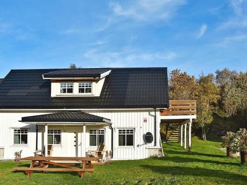 una casa blanca con una mesa de picnic delante de ella en 4 person holiday home in Oksvoll, en Oksvoll