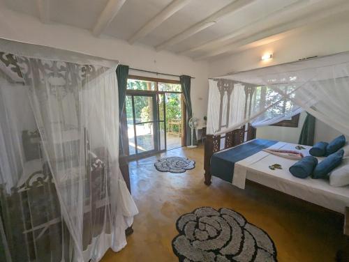 een slaapkamer met een hemelbed met blauwe kussens bij Kivulini Lodge in Utende