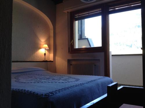 a bedroom with a bed and a window at Condominio Colmet in La Thuile