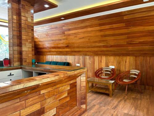 - un sauna avec des murs en bois et des chaises bleues dans l'établissement Suvarna Eco Village, à Madikeri