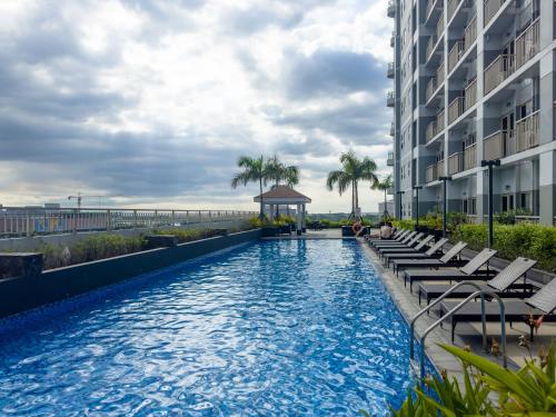 a swimming pool with chairs and a gazebo on a building at GemstoneBR in SMDC Coast Residences in Manila