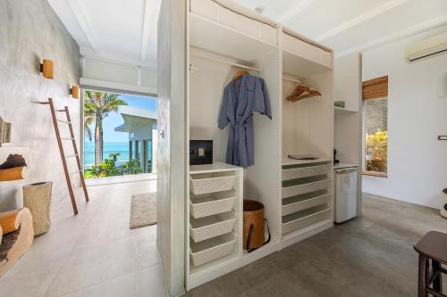 einen begehbaren Kleiderschrank mit einem blauen Bademantel in der Unterkunft Villa Playa Samui in Strand Choeng Mon