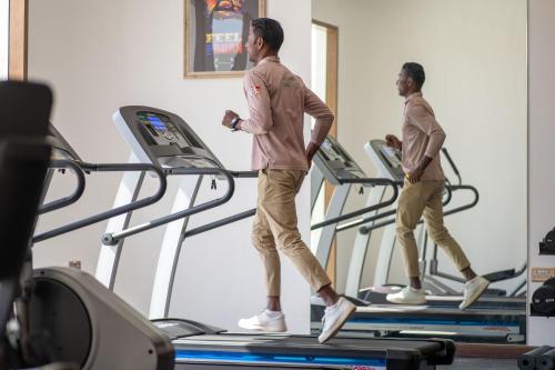 two men walking on a treadmill in a gym at Western Hotel Liwa in Liwa