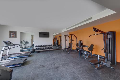 a gym with a bunch of treadmills and machines at Western Hotel Liwa in Liwa