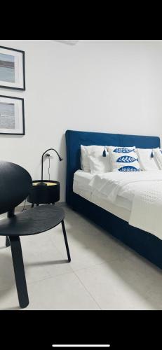 een slaapkamer met een bed met een tafel en een stoel bij בלקוני לחוף דור in Dor