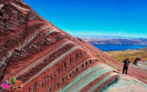 a person standing on the side of a rock at Hostal Inca in San Pedro