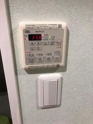 an alarm clock is attached to the wall at Apartment Heights HANA in Sakai