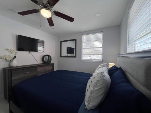 a bedroom with a blue bed and a ceiling fan at Charming two bedroom apartment. in Miami