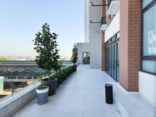 a walkway with potted trees and plants on a building at FOX Hotel Glenmarie Shah Alam in Shah Alam