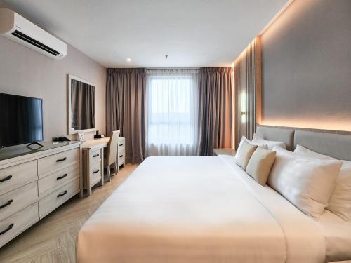 een hotelkamer met een groot bed en een televisie bij FOX Hotel Glenmarie Shah Alam by The Ascott in Shah Alam