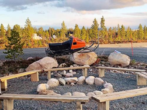 une motoneige orange garée à côté des bûches et des rochers dans l'établissement 12 person holiday home in IDRE, à Idre